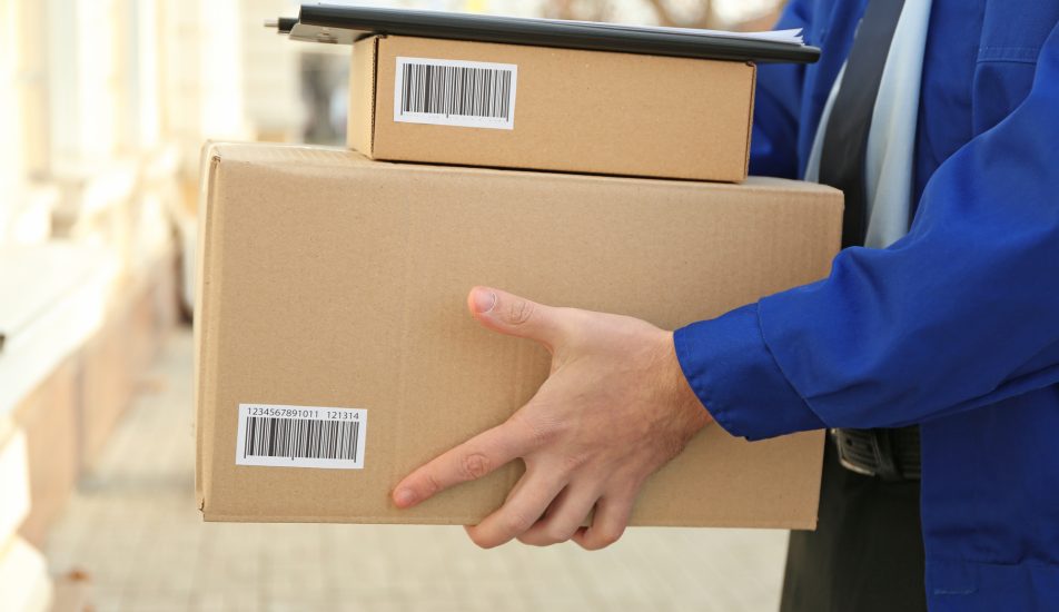 Courier with parcels on doorstep, closeup